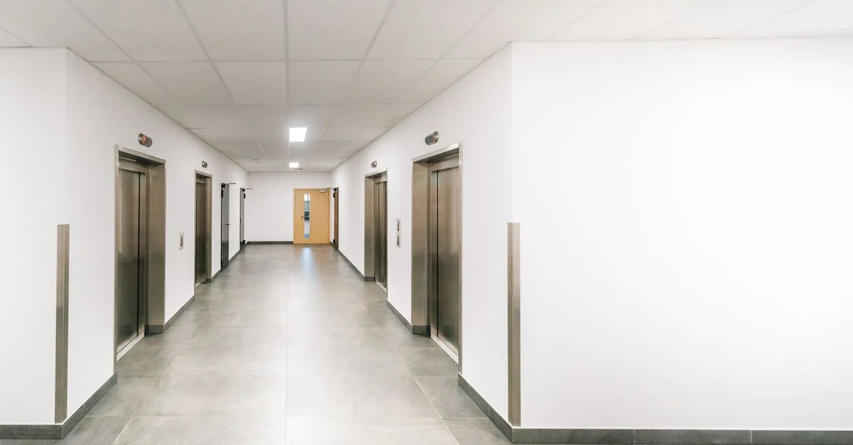 Couloir de bureau lumineux et propre avec plusieurs ascenseurs modernes en acier inoxydable.