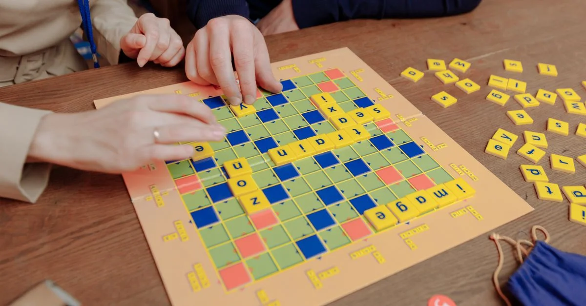 Un gros plan de personnes jouant à un jeu de société de mots à l'intérieur, améliorant les compétences cognitives.