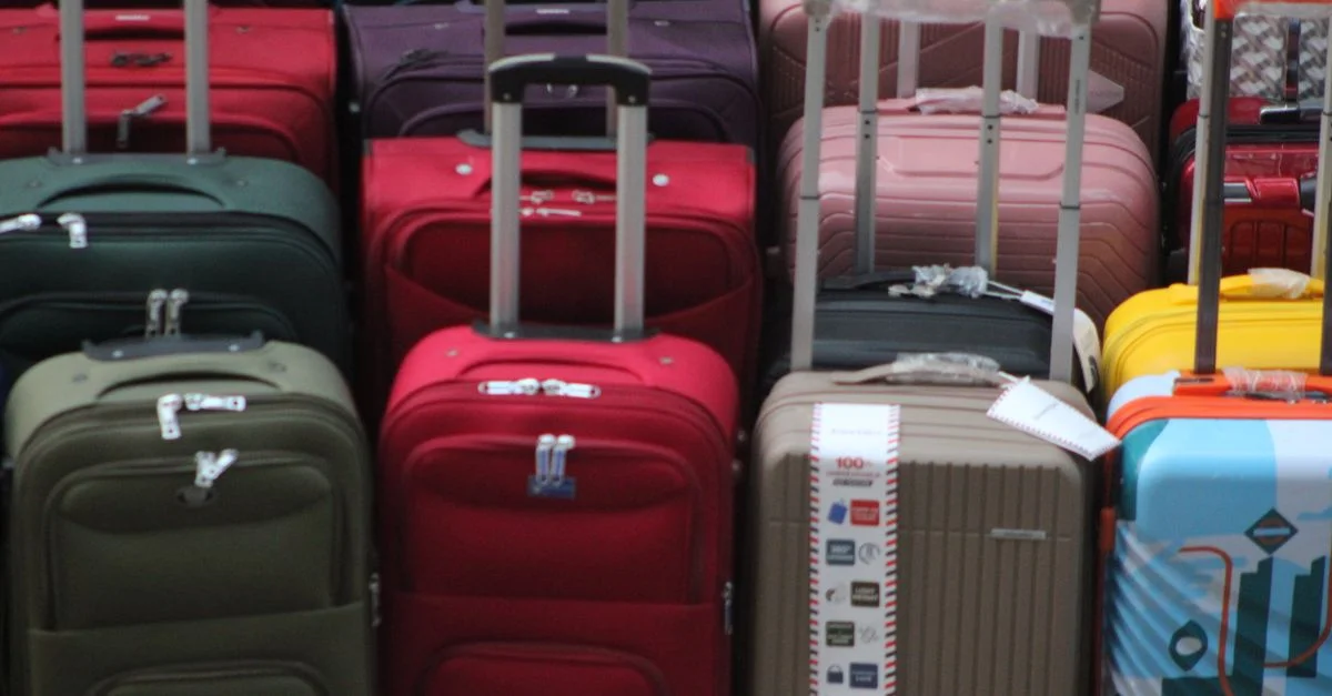 Une collection colorée de valises diverses, empilées en prévision d'un voyage.