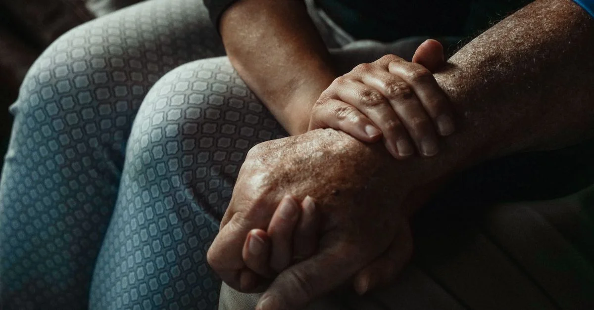Un gros plan de mains exprimant soutien et compassion dans un moment intime.