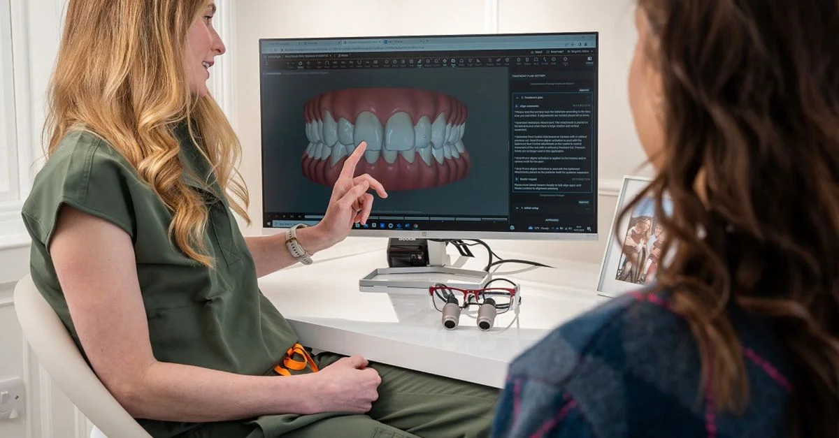Un dentiste explique un modèle dentaire 3D à un patient lors d'une consultation à Édimbourg.