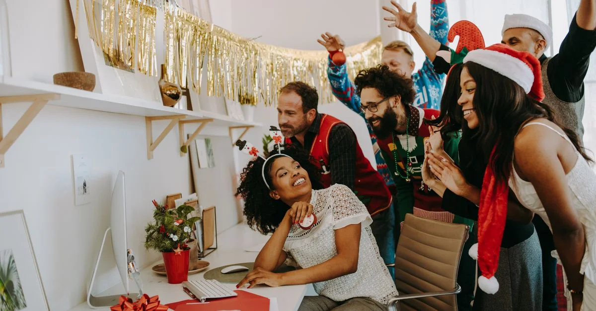 Groupe de collègues en vêtements de Noël célébrant les fêtes au bureau.
