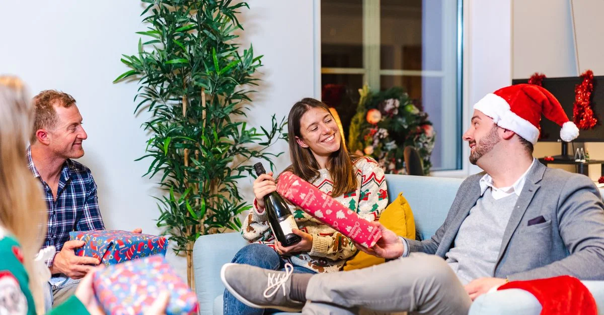 Une joyeuse fête de Noël au bureau avec des collègues échangeant des cadeaux et profitant de l'atmosphère festive à l'intérieur.