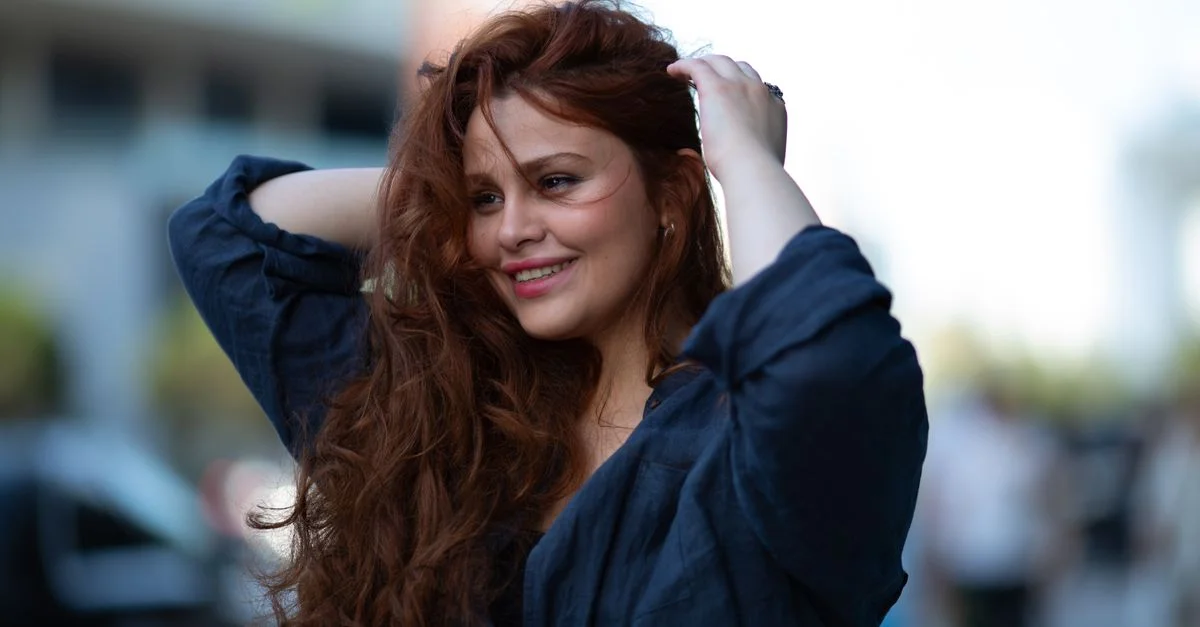 Portrait d'une femme souriante aux cheveux flottants par une journée ensoleillée à Bakou, en Azerbaïdjan.