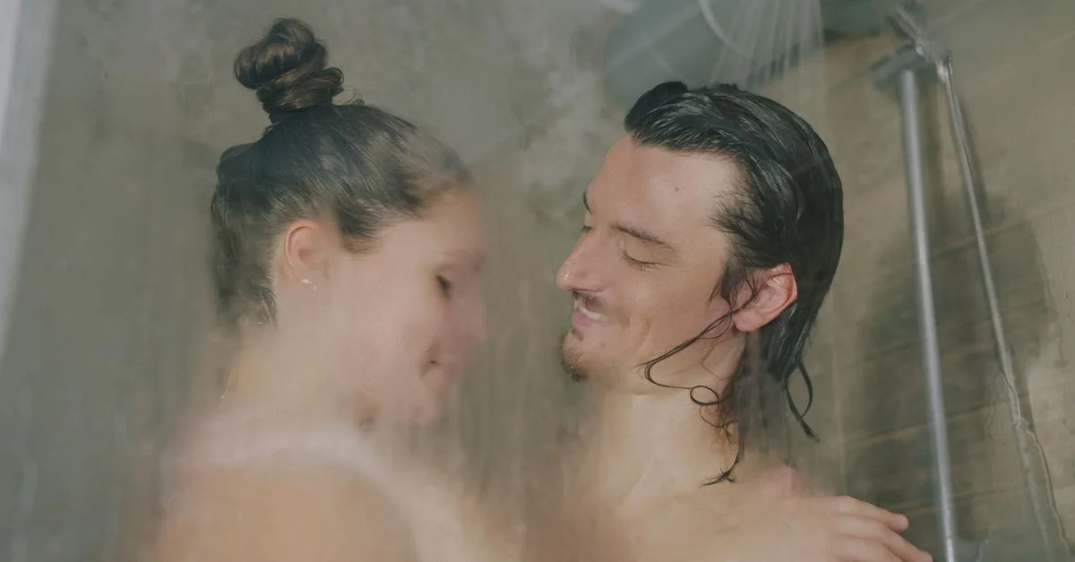 Un couple romantique partage un tendre moment sous la douche, profitant d'un moment privilégié.