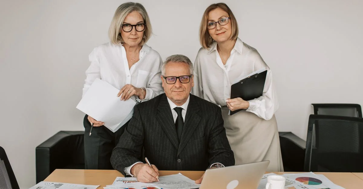 Des professionnels seniors en réunion d'affaires, discutant des graphiques et des données dans le bureau.