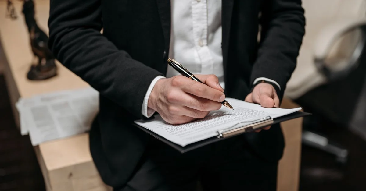 Professionnel des affaires signant un contrat sur une planche à clip au bureau.