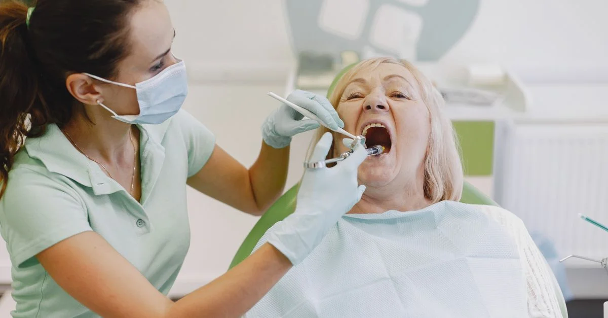 Une dentiste examine une patiente senior dans un cadre de clinique dentaire.