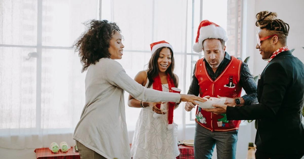 Des collègues échangent des cadeaux lors d'une joyeuse fête de Noël au bureau.