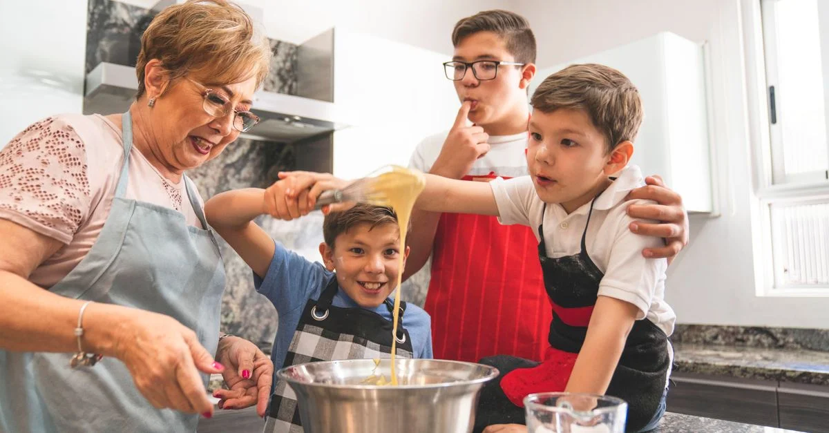 Grand-mère et petits-fils prennent plaisir à cuisiner ensemble, créant des souvenirs spéciaux dans la cuisine.