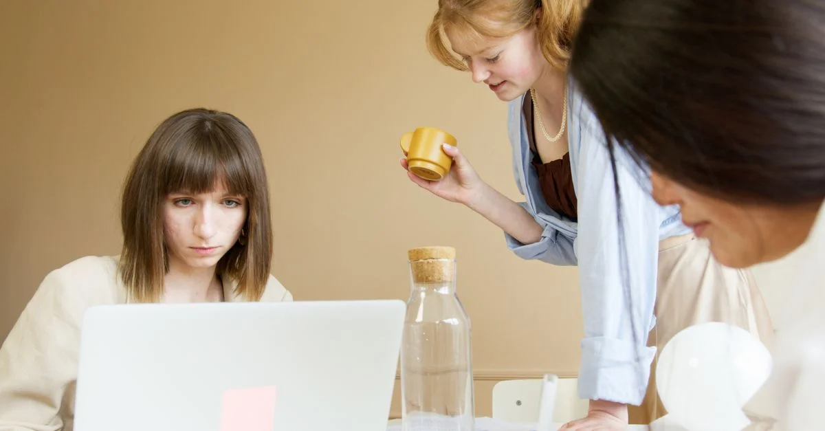 Un groupe de femmes diversifiées travaillant ensemble dans un environnement de bureau moderne, favorisant la créativité et la collaboration.