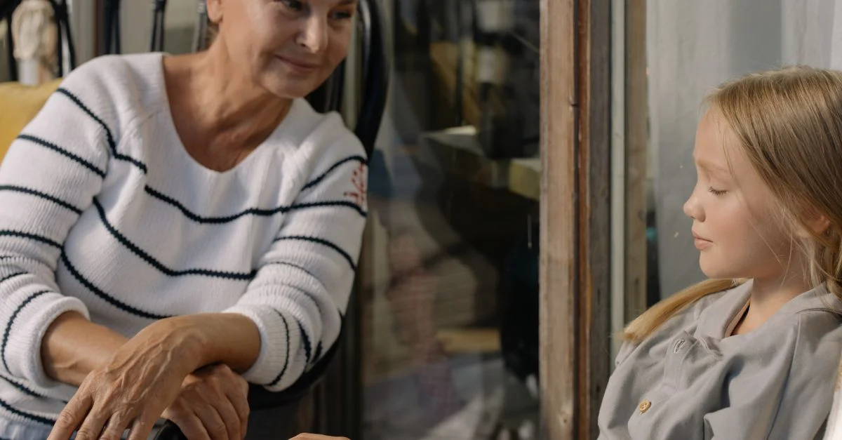 Scène réconfortante d'une grand-mère et de sa petite-fille partageant un moment tendre de complicité à l'intérieur.