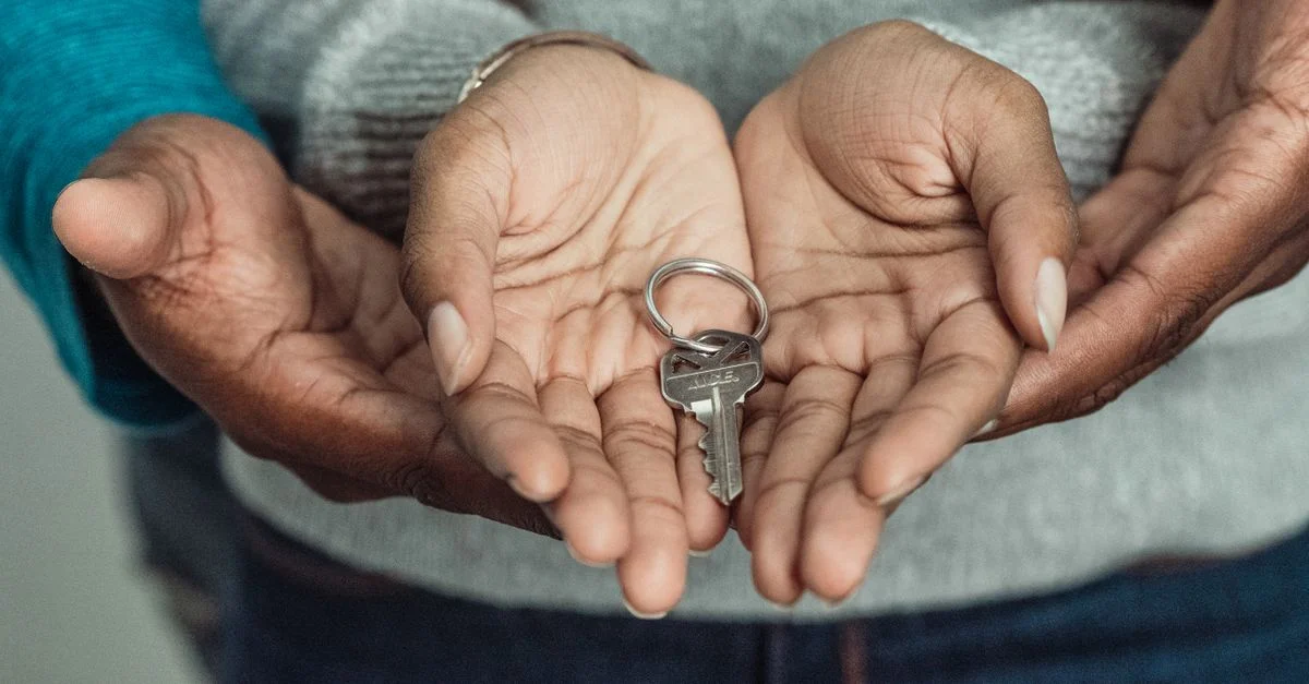 Gros plan d'un couple partageant une clé, symbolisant l'acquisition d'une nouvelle maison.
