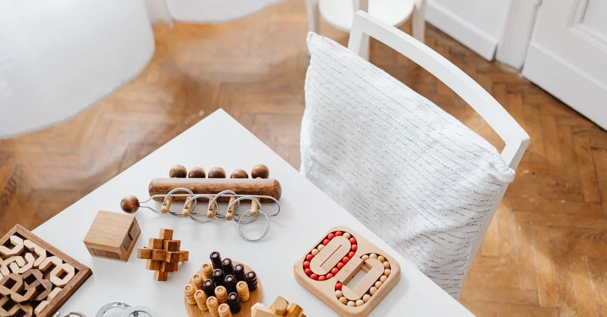 Une collection de jouets en bois disposés sur une table moderne dans un cadre intérieur, parfaits pour encourager le jeu intellectuel.
