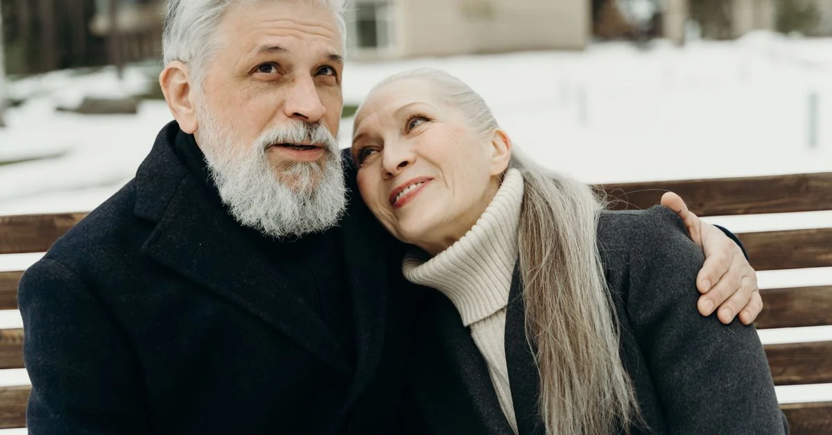 Couple senior partageant une étreinte sincère à l'extérieur en hiver.