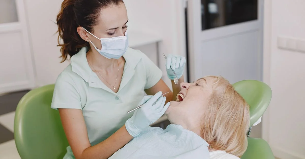 Une dentiste examine un patient dans un cabinet dentaire, soulignant des soins dentaires professionnels.