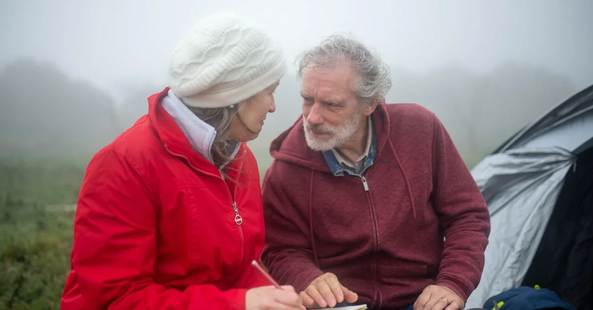 Couple âgé en camping dans la brume, écrivant dans un carnet, voyage au Portugal