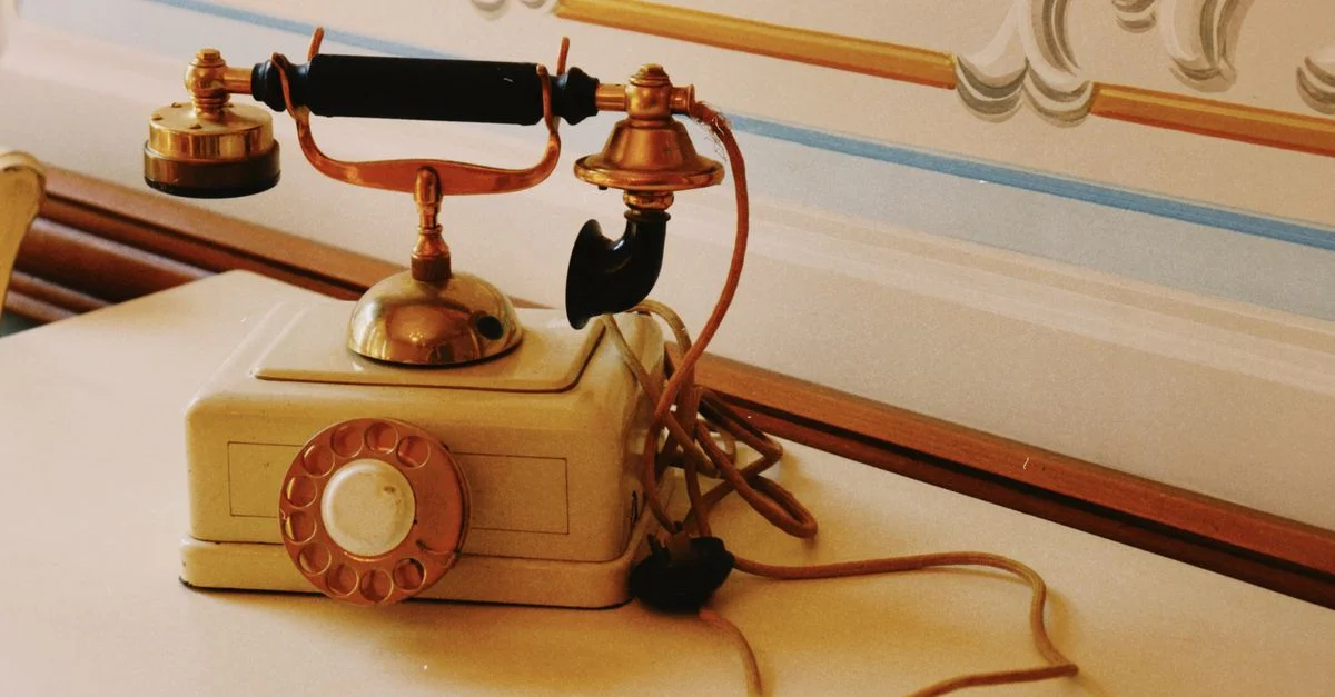 Un téléphone à cadran vintage classique avec des détails ornés sur une table décorative, véhiculant un charme rétro.