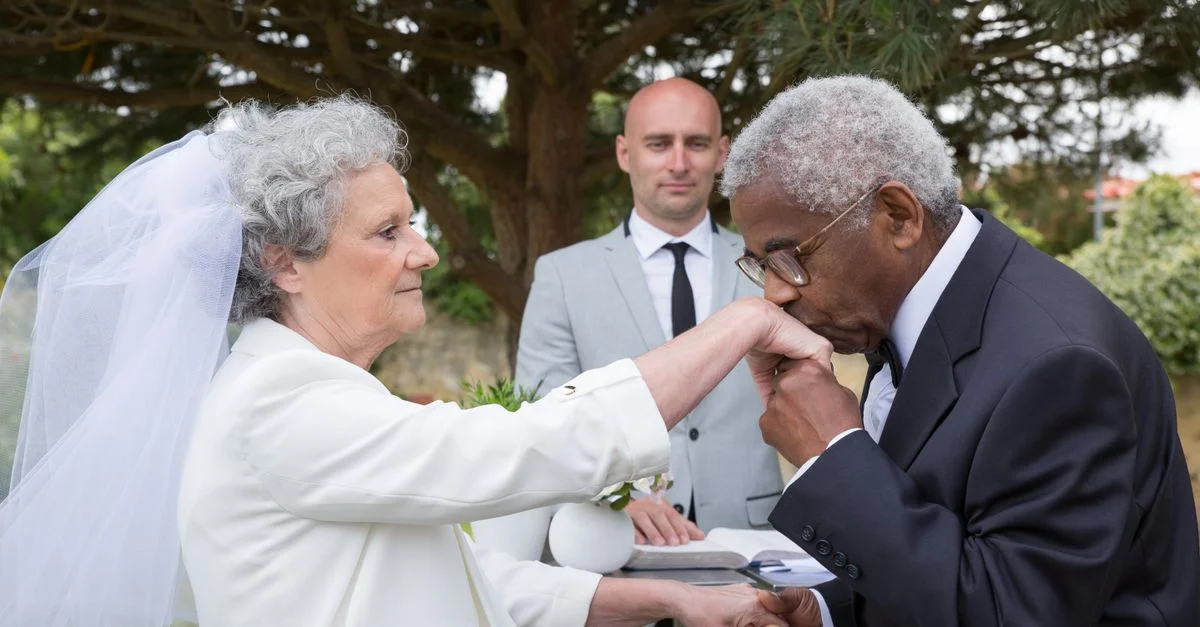 Un mariage en plein air touchant d'un couple âgé échangeant des vœux au Portugal avec un baiser sur la main.