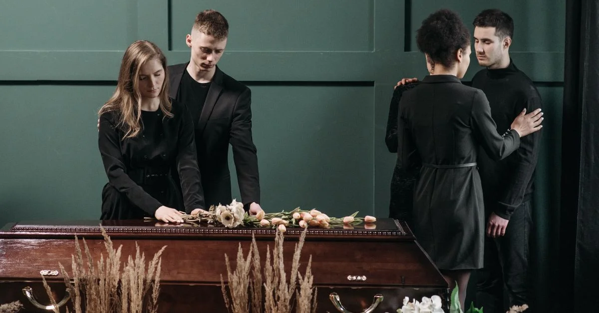 Une scène funéraire émouvante avec des personnes rendant hommage à un être cher.
