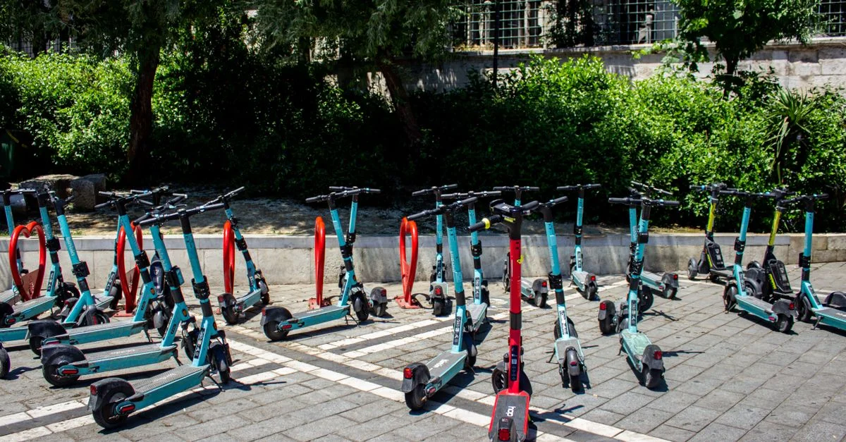 Une rangée de scooters électriques alignés sur un parking extérieur à Istanbul, en Turquie.