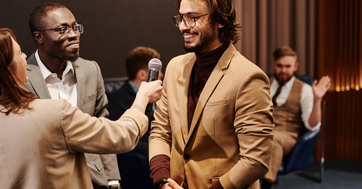 Des professionnels souriants engagés dans un cadre d'interview amical avec un microphone à l'intérieur.
