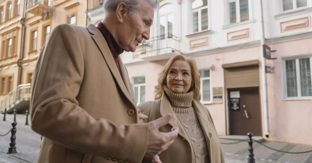 Un couple âgé profite d'une promenade ensemble dans une charmante rue européenne.